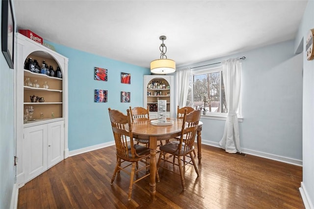 dining area featuring built in features and dark hardwood / wood-style flooring