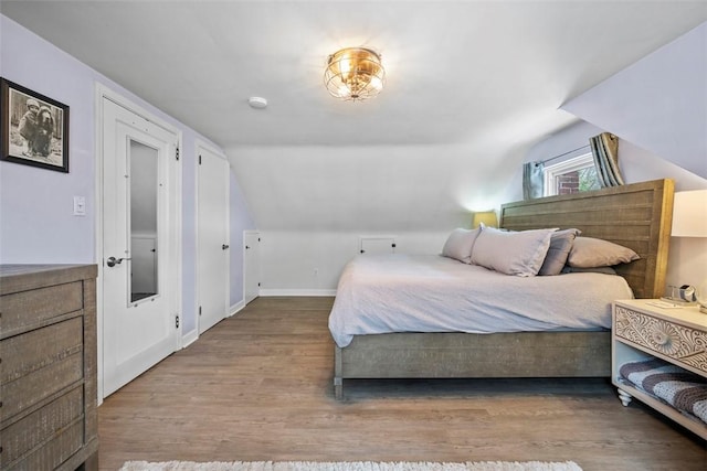 bedroom with lofted ceiling and hardwood / wood-style flooring