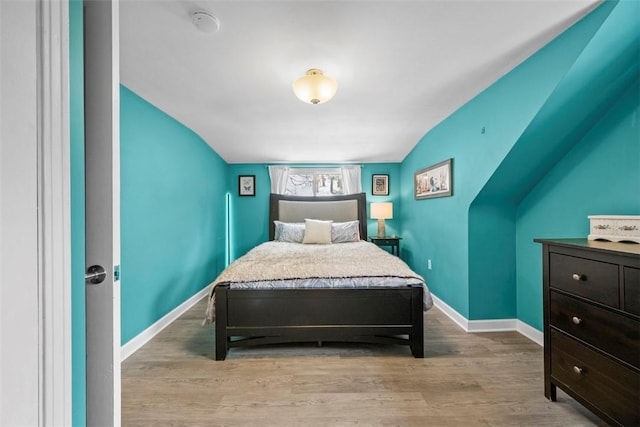 bedroom featuring lofted ceiling and light hardwood / wood-style flooring