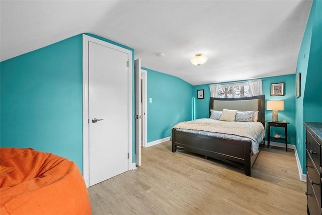 bedroom with vaulted ceiling and light hardwood / wood-style flooring