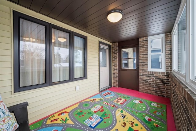 sunroom with a healthy amount of sunlight and wood ceiling