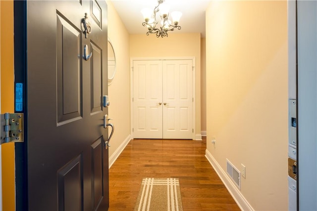 doorway featuring hardwood / wood-style floors and a notable chandelier