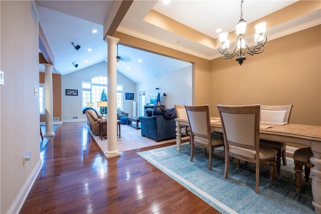 dining space with dark wood-type flooring, a notable chandelier, and ornate columns