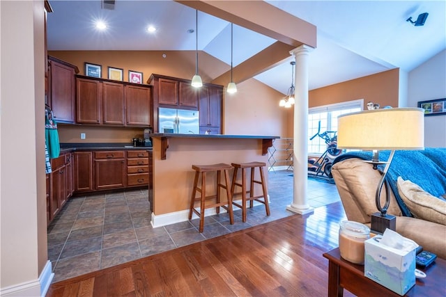 kitchen featuring decorative columns, a kitchen breakfast bar, decorative light fixtures, and stainless steel built in fridge