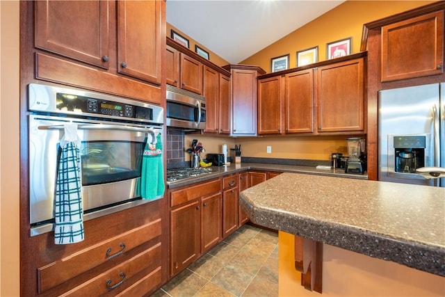 kitchen with appliances with stainless steel finishes and lofted ceiling