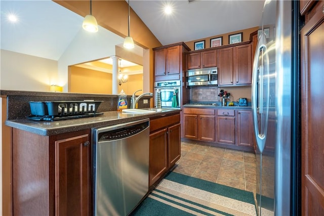 kitchen with stainless steel appliances, tasteful backsplash, sink, hanging light fixtures, and vaulted ceiling