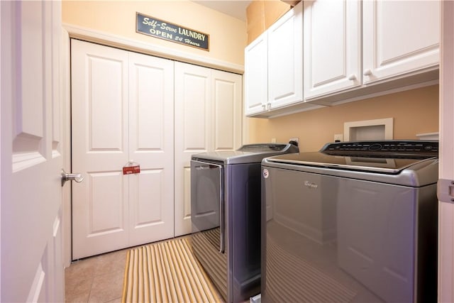 laundry room featuring light tile patterned flooring, independent washer and dryer, and cabinets