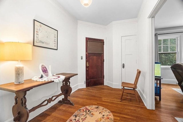 foyer entrance featuring crown molding and hardwood / wood-style flooring