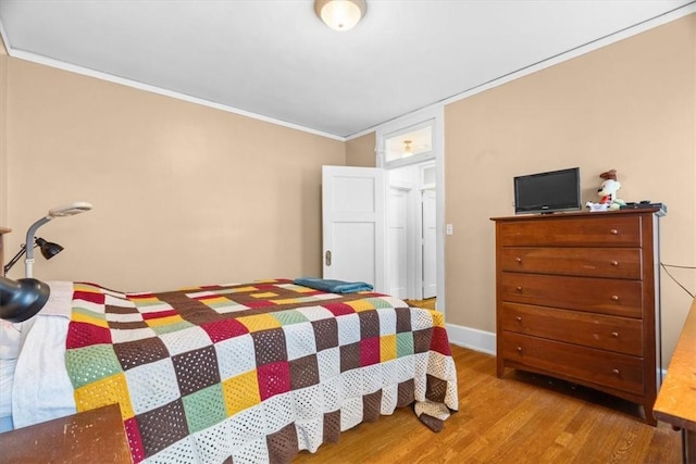 bedroom featuring wood-type flooring and ornamental molding