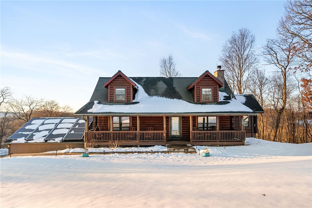 log-style house featuring covered porch and solar panels