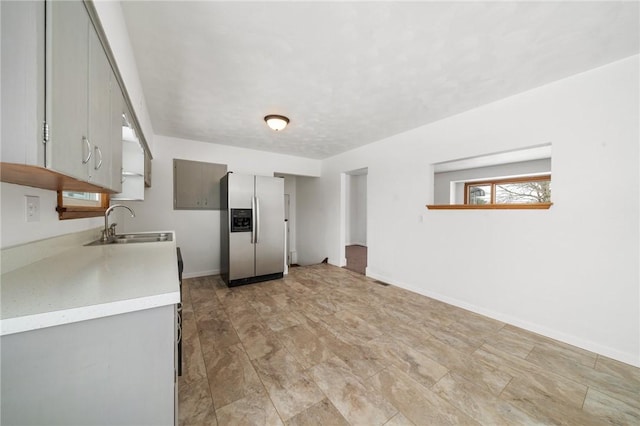 kitchen featuring sink, gray cabinets, and stainless steel fridge with ice dispenser