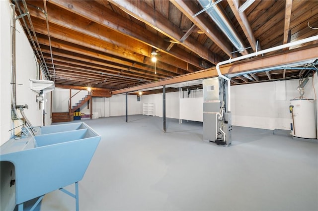 basement featuring water heater, sink, and heating unit