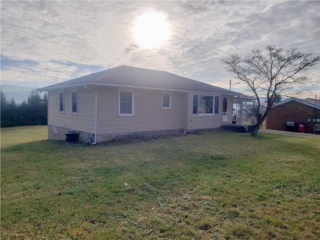 view of home's exterior with a yard and central AC