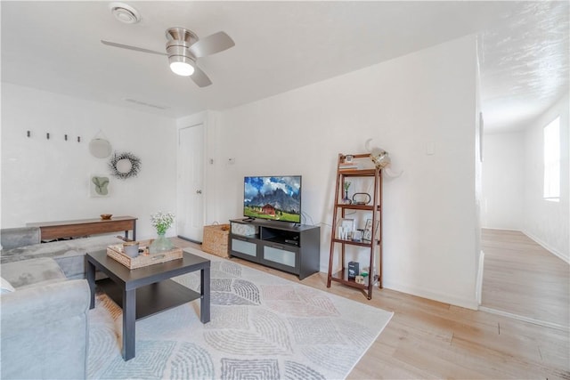 living room with ceiling fan and light hardwood / wood-style flooring