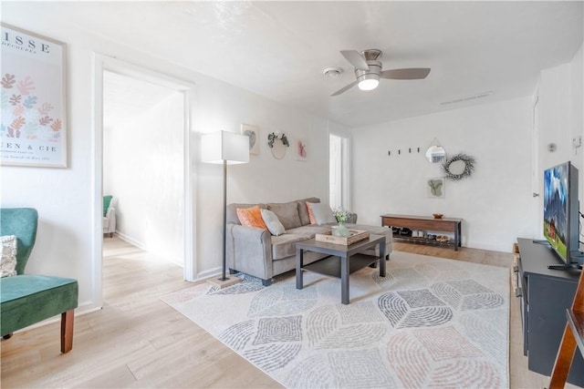 living room with ceiling fan and light hardwood / wood-style flooring