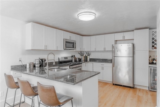 kitchen with white cabinetry, kitchen peninsula, and stainless steel appliances