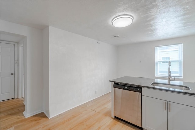 kitchen featuring white cabinetry, light wood-type flooring, dishwasher, a textured ceiling, and sink