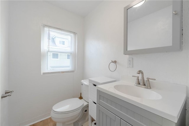 bathroom featuring plenty of natural light, toilet, and vanity