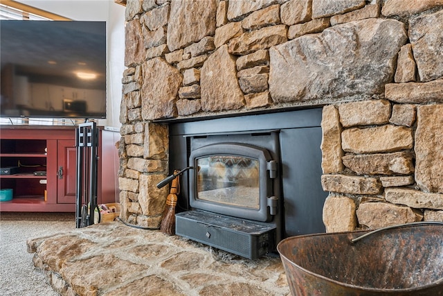 interior details with a wood stove and carpet flooring