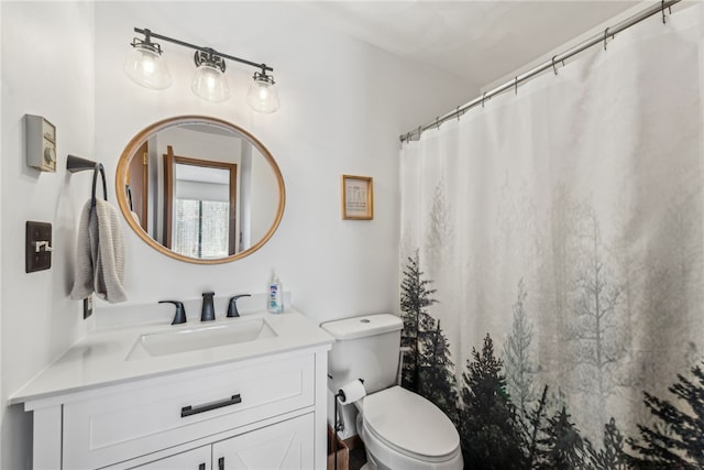 bathroom featuring toilet, vanity, and a shower with curtain