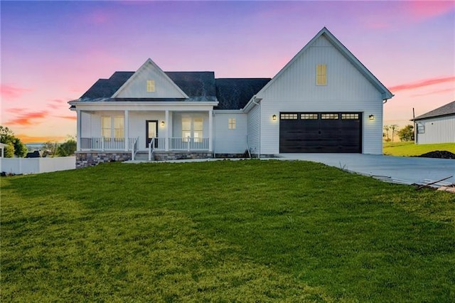 modern inspired farmhouse featuring a yard, covered porch, and a garage