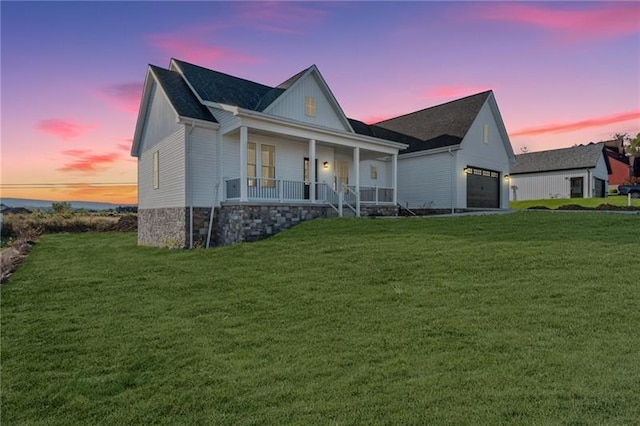 view of front of home featuring a garage, a porch, and a lawn