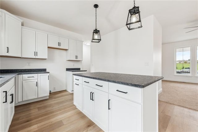 kitchen with white cabinetry, hanging light fixtures, and a kitchen island