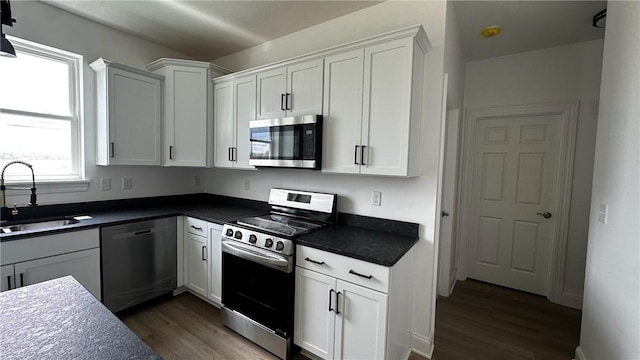 491 Shannon Dr, Mount Pleasant Twp Wml, PA 15666 - kitchen with appliances with stainless steel finishes, dark wood-style floors, dark countertops, and white cabinets