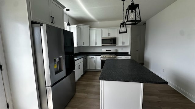491 Shannon Dr, Mount Pleasant Twp Wml, PA 15666 - kitchen with appliances with stainless steel finishes, dark countertops, a kitchen island, white cabinetry, and dark wood-style floors