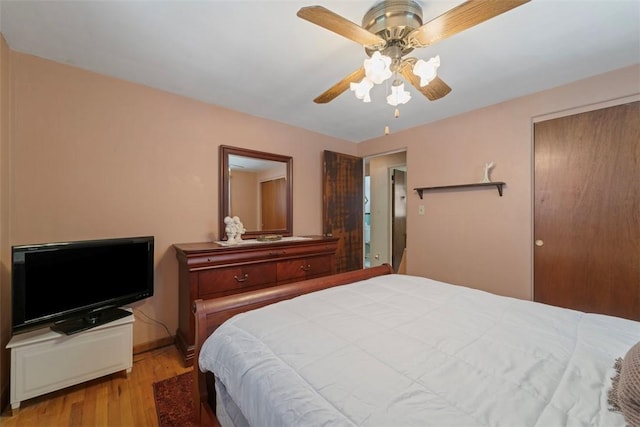 bedroom featuring ceiling fan, light hardwood / wood-style flooring, and a closet