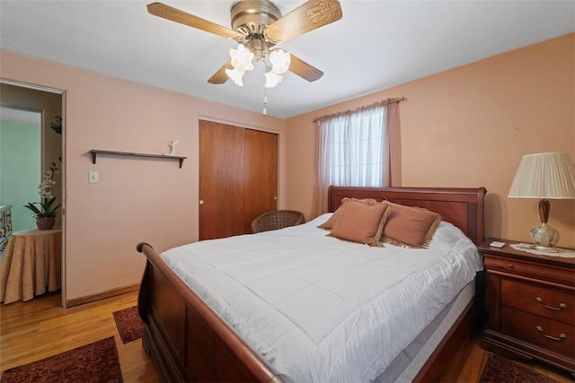 bedroom with ceiling fan, a closet, and light hardwood / wood-style flooring