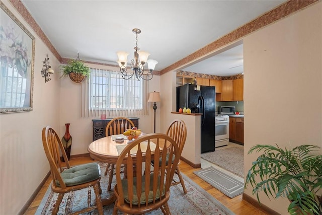 dining room with light wood-type flooring and a chandelier