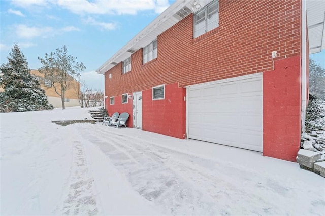 view of snow covered exterior with a garage