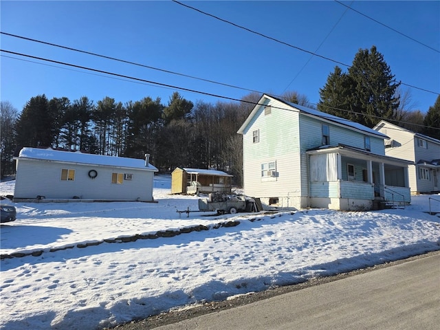 snow covered property with covered porch