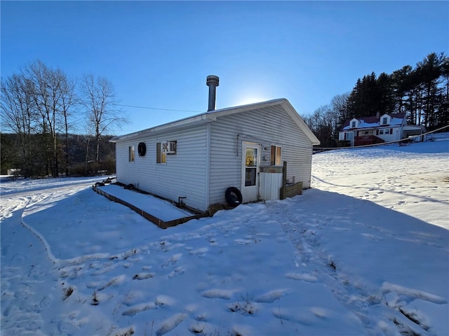 view of snow covered back of property