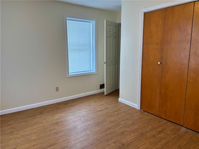 unfurnished bedroom with a closet and light hardwood / wood-style flooring