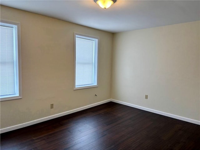 spare room featuring dark wood-type flooring and a wealth of natural light