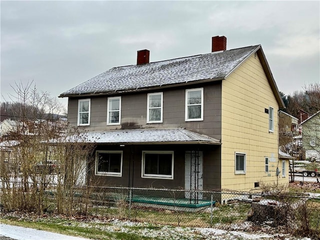 view of snow covered back of property