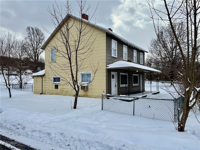 snow covered rear of property featuring covered porch