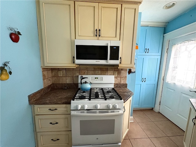 kitchen with cream cabinetry, backsplash, and white appliances