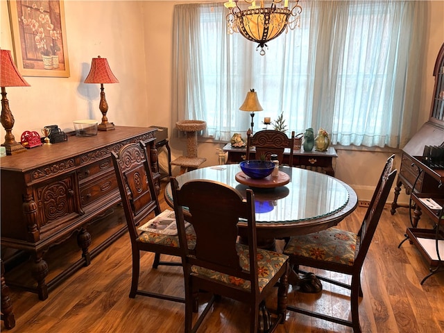 dining space featuring hardwood / wood-style floors and an inviting chandelier