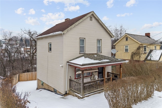 snow covered house featuring covered porch