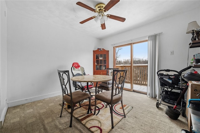 carpeted dining area with ceiling fan