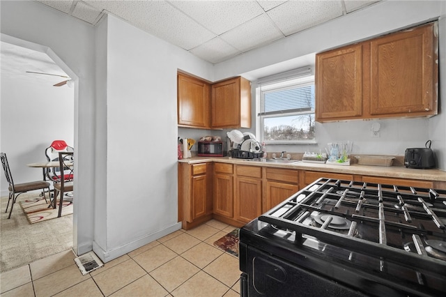 kitchen with range with gas cooktop, sink, a paneled ceiling, and light tile patterned flooring