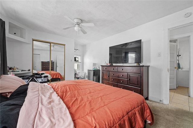 carpeted bedroom with ceiling fan, a closet, and a textured ceiling