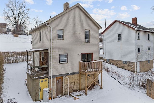 snow covered rear of property featuring a wooden deck