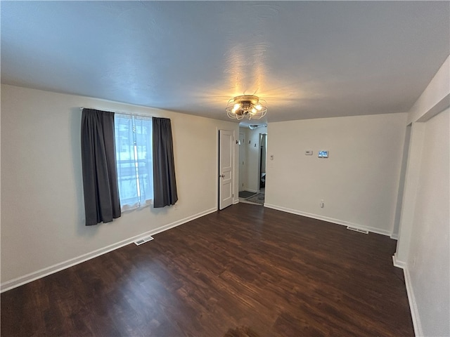 unfurnished room with dark wood-type flooring