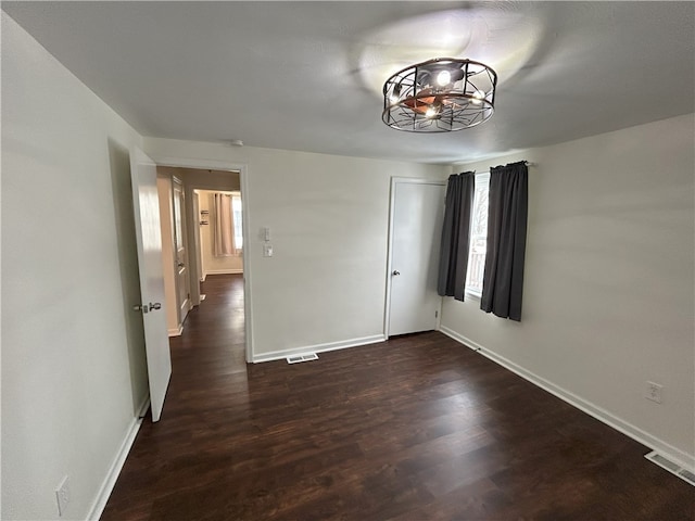 empty room with dark hardwood / wood-style flooring