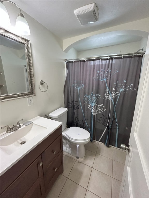 bathroom featuring toilet, walk in shower, tile patterned floors, and vanity