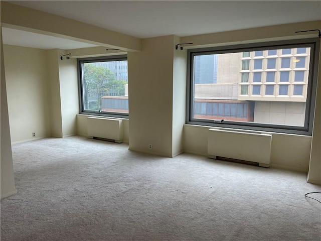 carpeted spare room with radiator heating unit